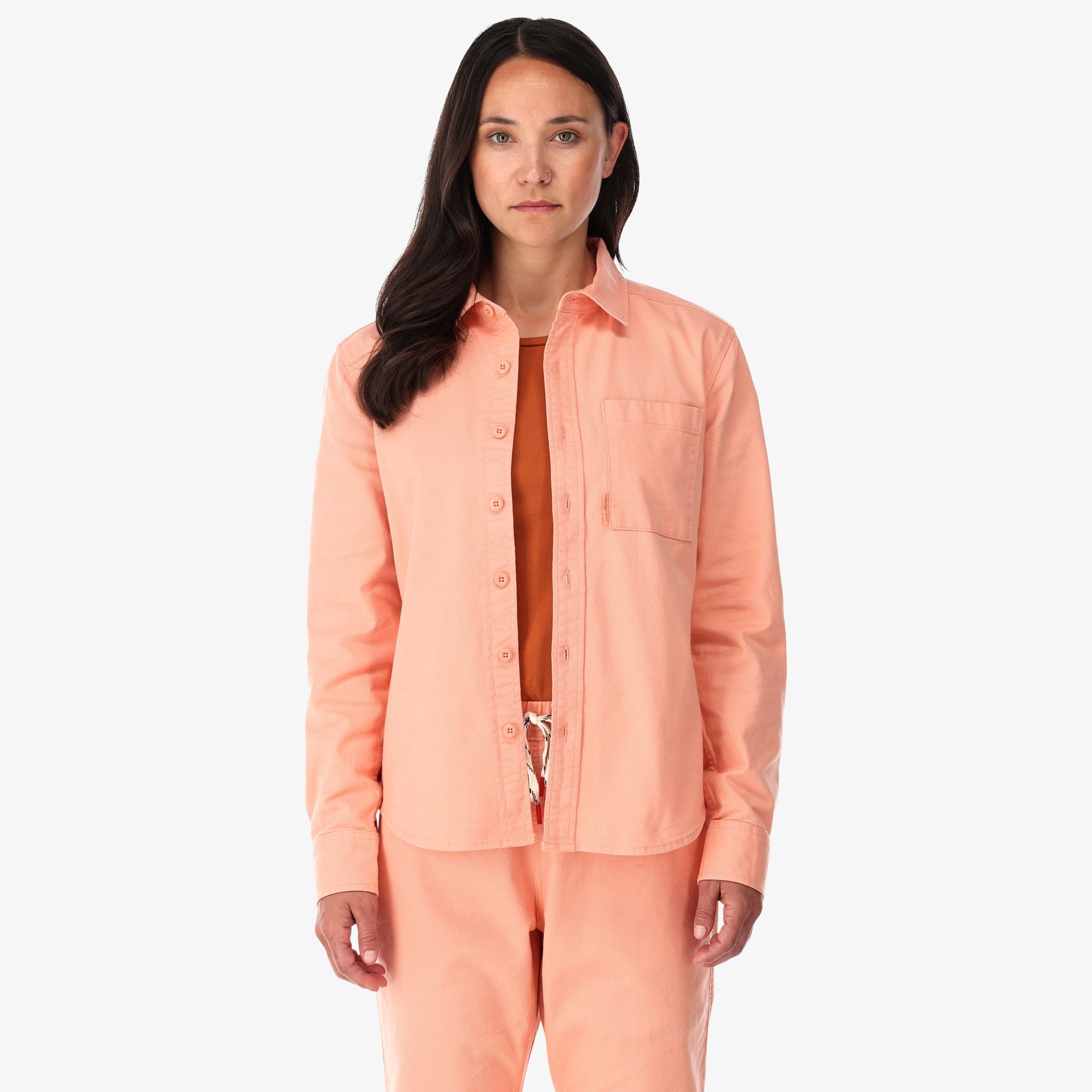 Topo Designs Women's Dirt Shirt long sleeve stretch cotton button-up in "peach" pink on model front.