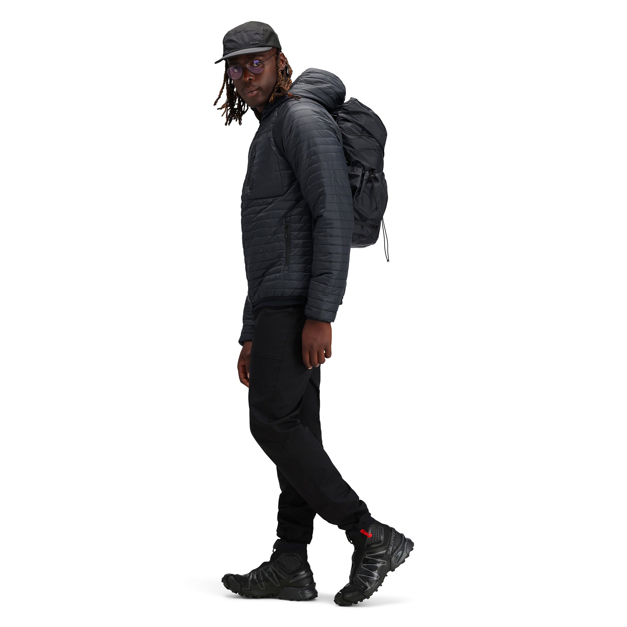 Model wearing Topo Designs TopoLite Cinch Pack 16L packable daypack backpack for travel in "black"