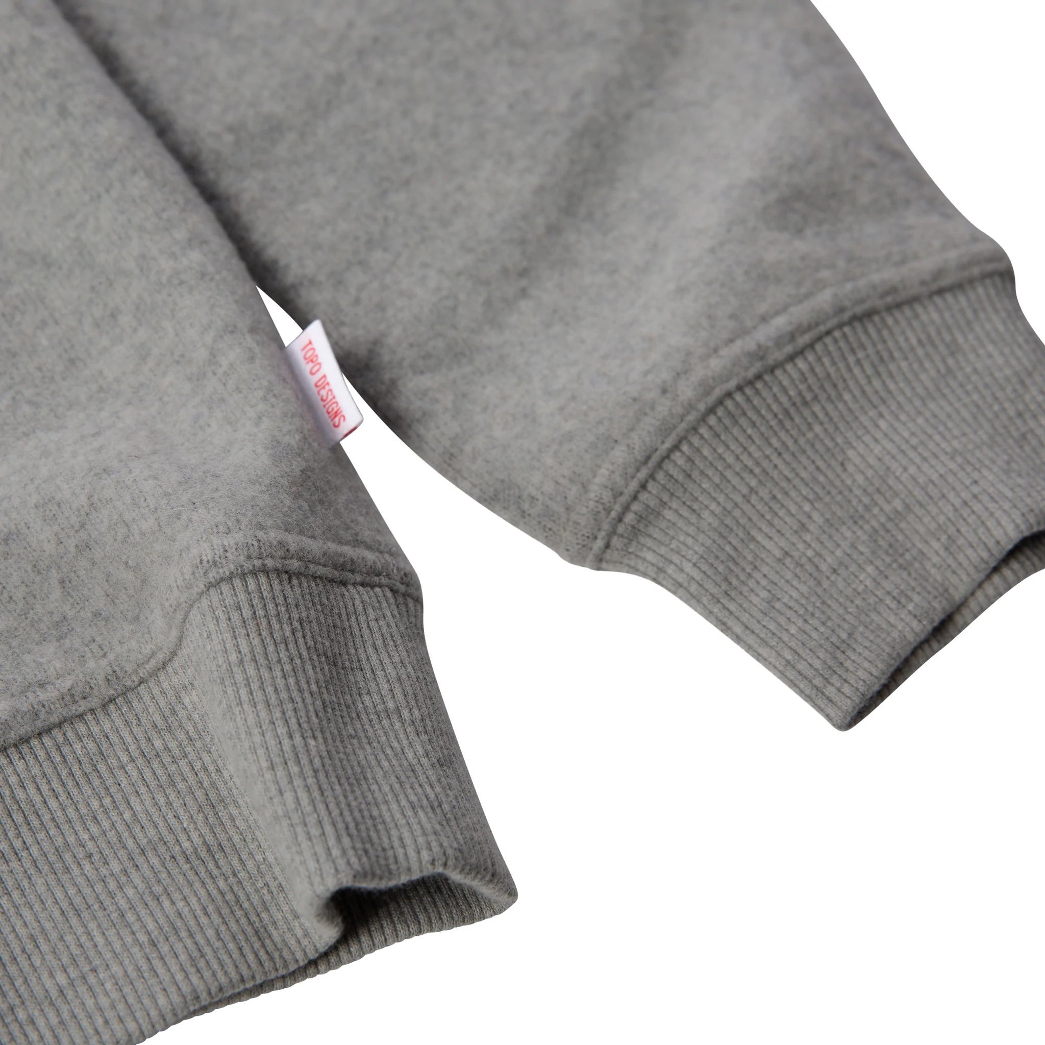 General detail shot of women's global sweater in gray showing sleeve hem.