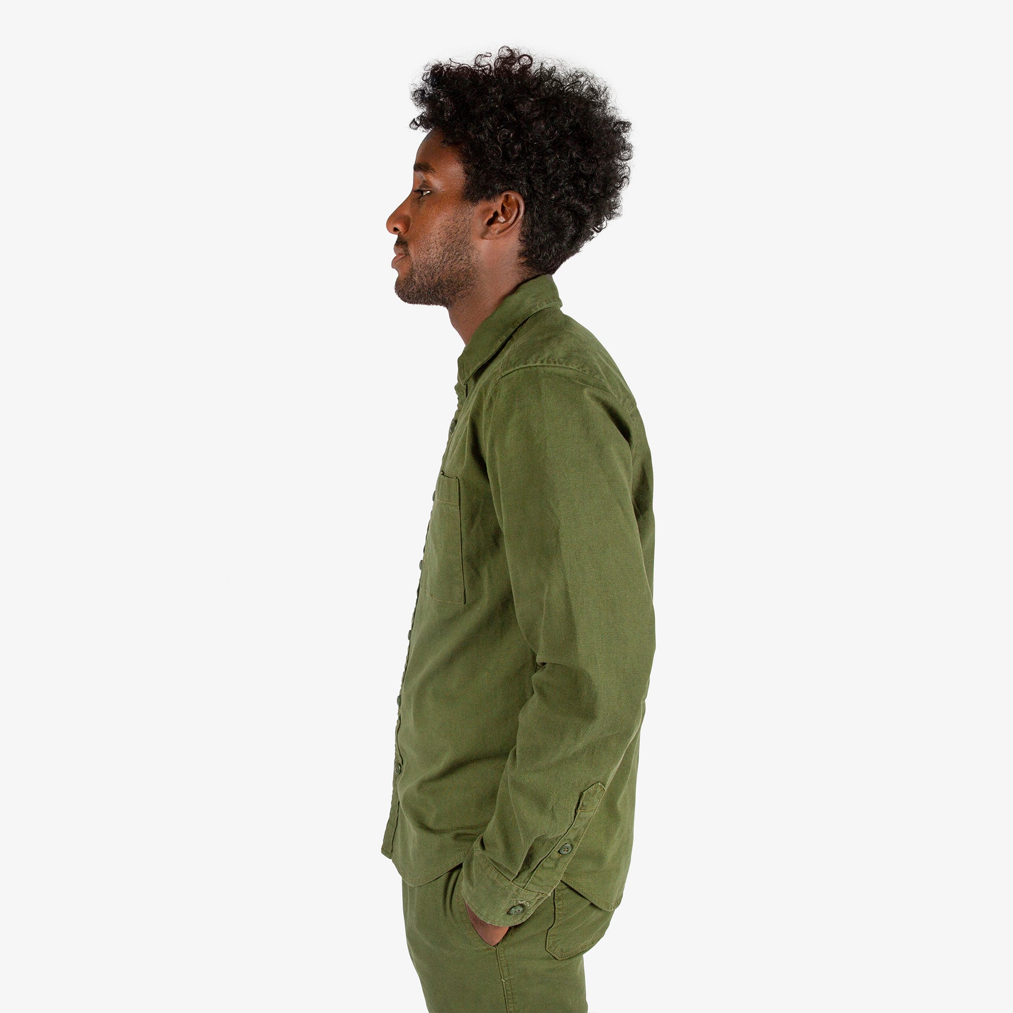 Close-up side model shot of Topo Designs Men's Dirt Shirt & Pants in "Olive".