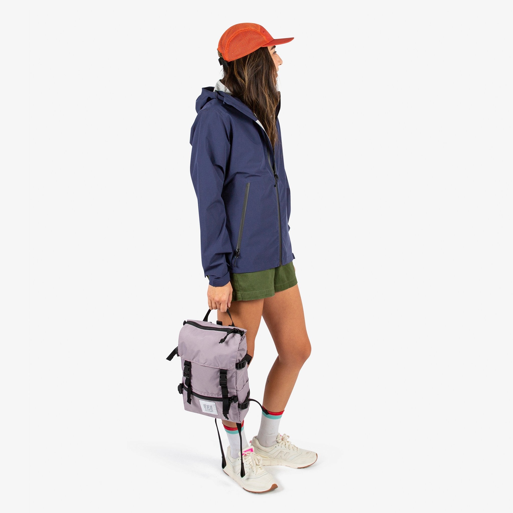 Topo Designs Rover Pack Mini backpack in Light purple held by model with top carry handle.