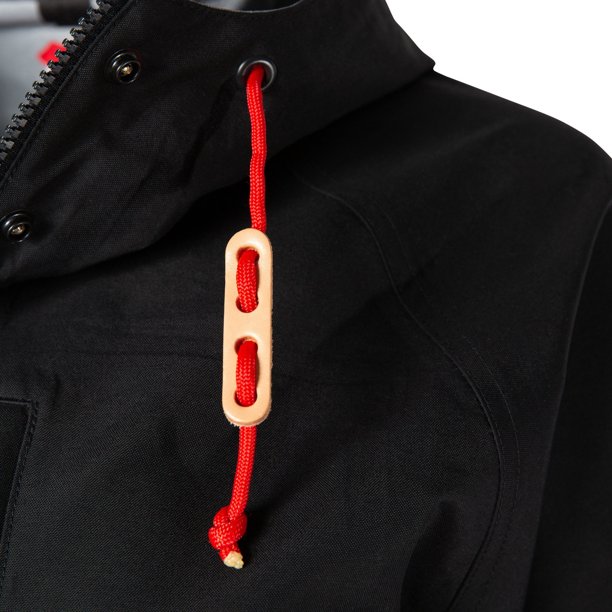 Detail product shot of women's tech trench 3L in black showing natural leather toggles