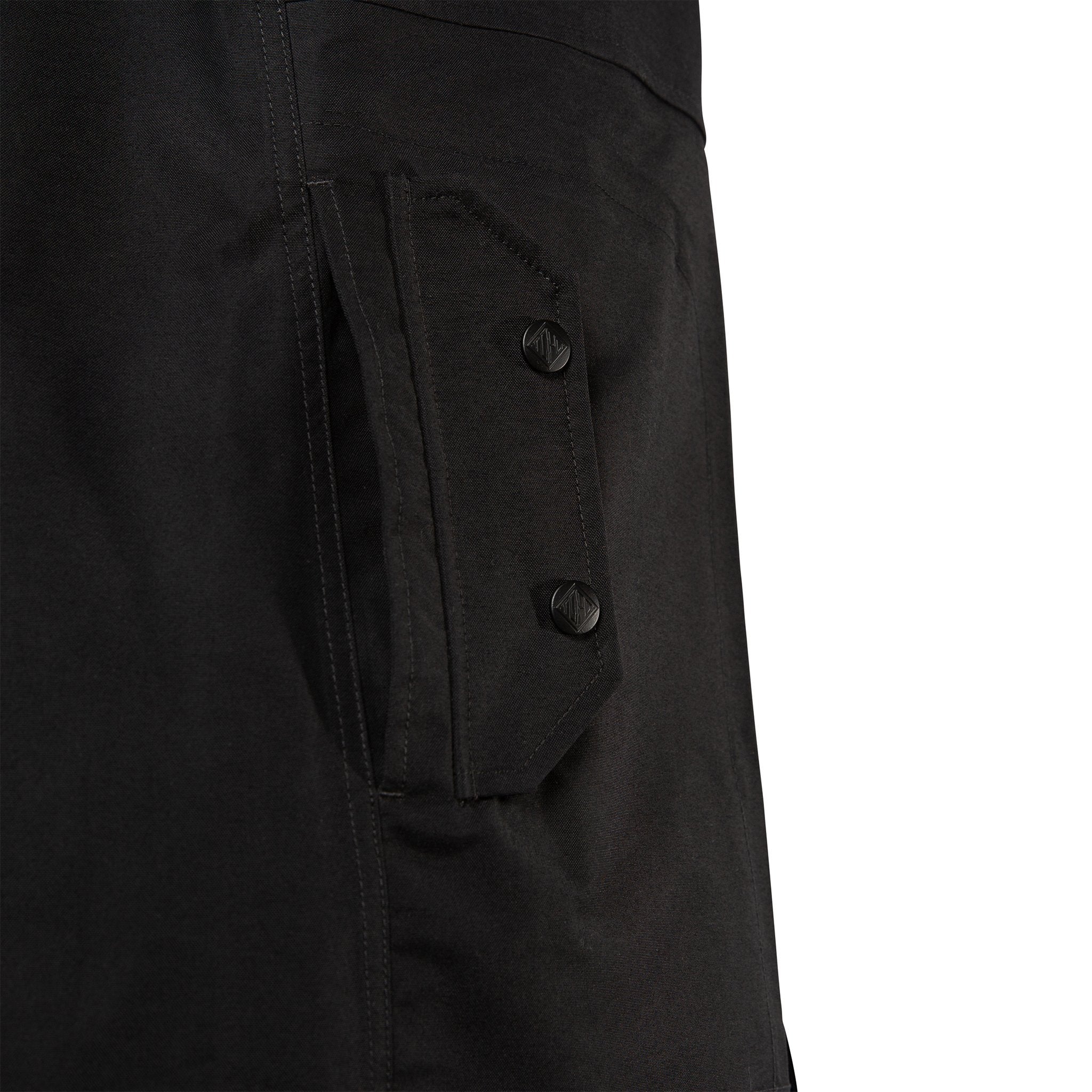 Detail product shot of women's tech trench 3L in black showing snap closure front pocket