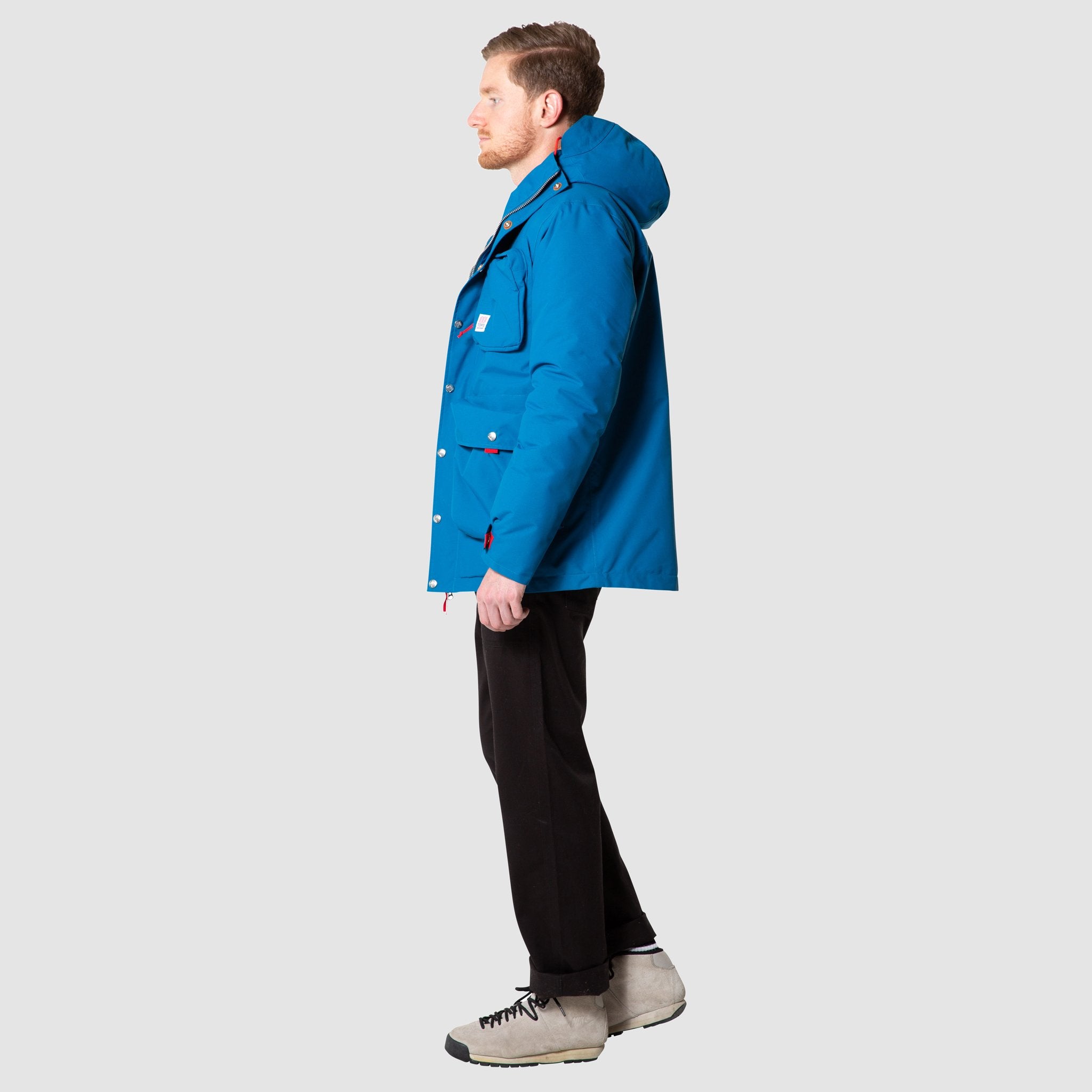 Full body side model shot of men's mountain jacket in blue, unzipped