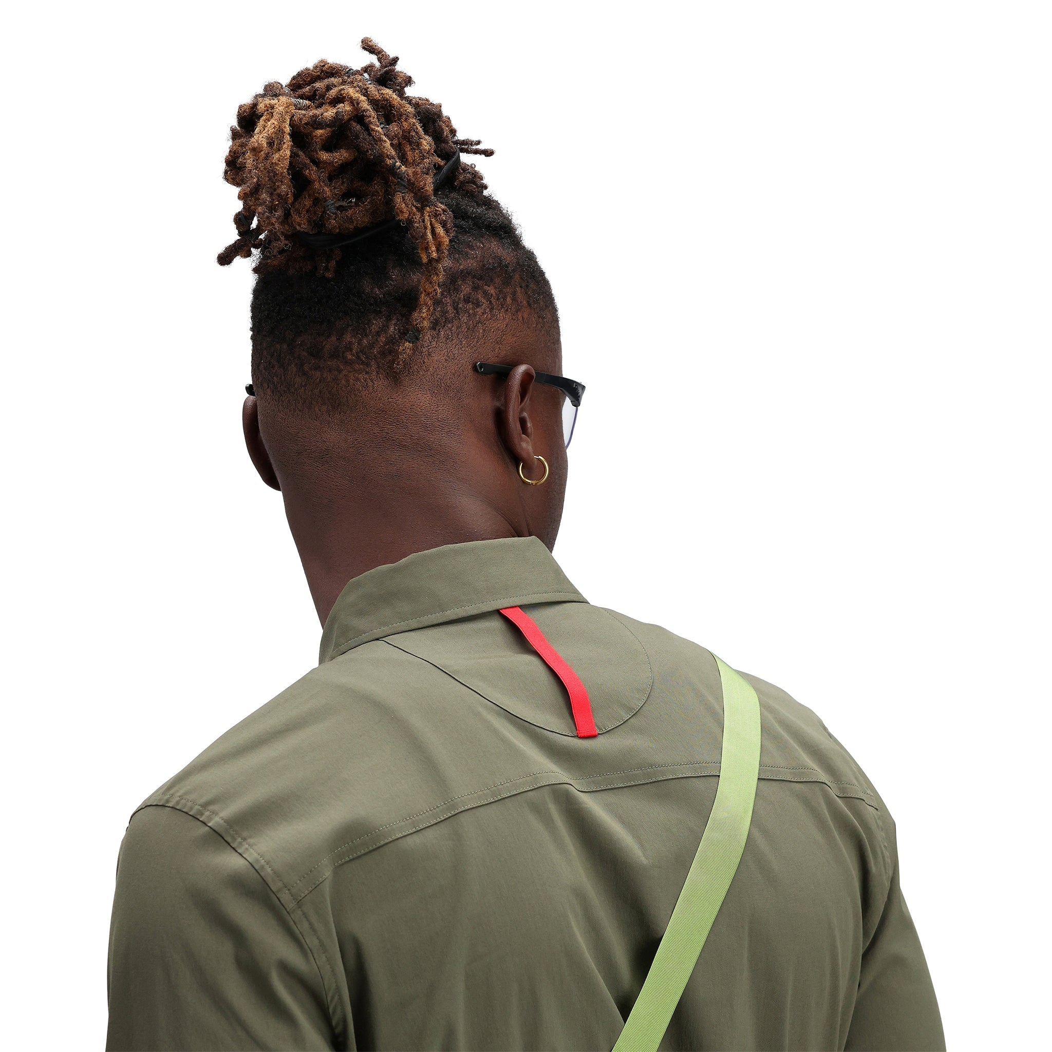 Detail shot of packfast packing band on back of model wearing Topo Designs Men's Global Shirt long sleeve lightweight travel snap shirt in "olive" green.