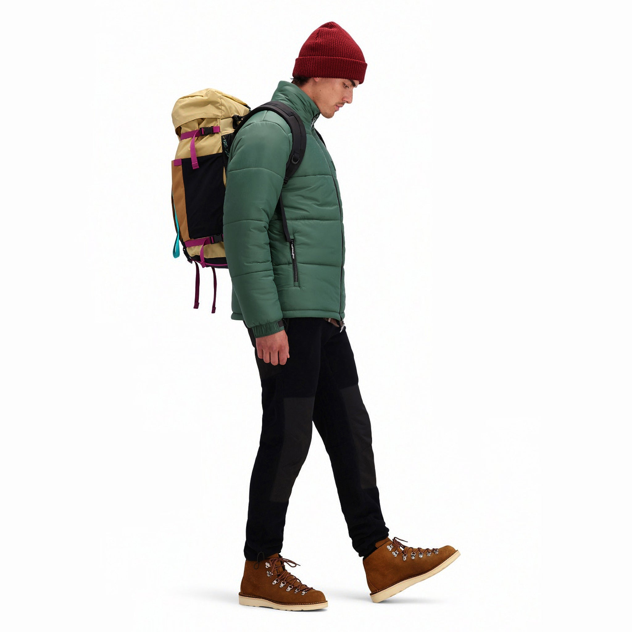 Side model shot of Topo Designs Men's Puffer recycled insulated Jacket in "Forest" green.