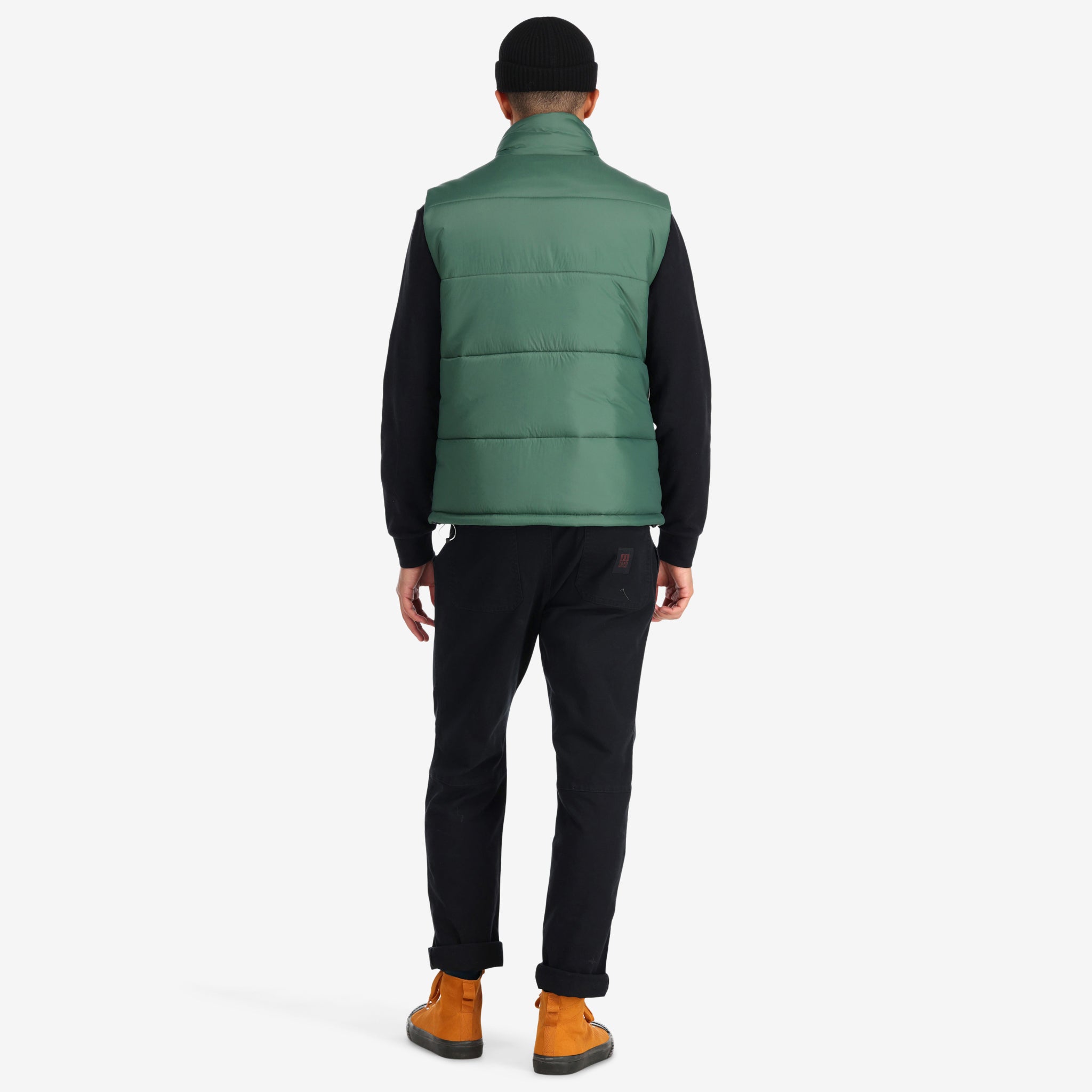 Back model shot of Topo Designs Men's Mountain Puffer recycled insulated Vest in "Forest" green.