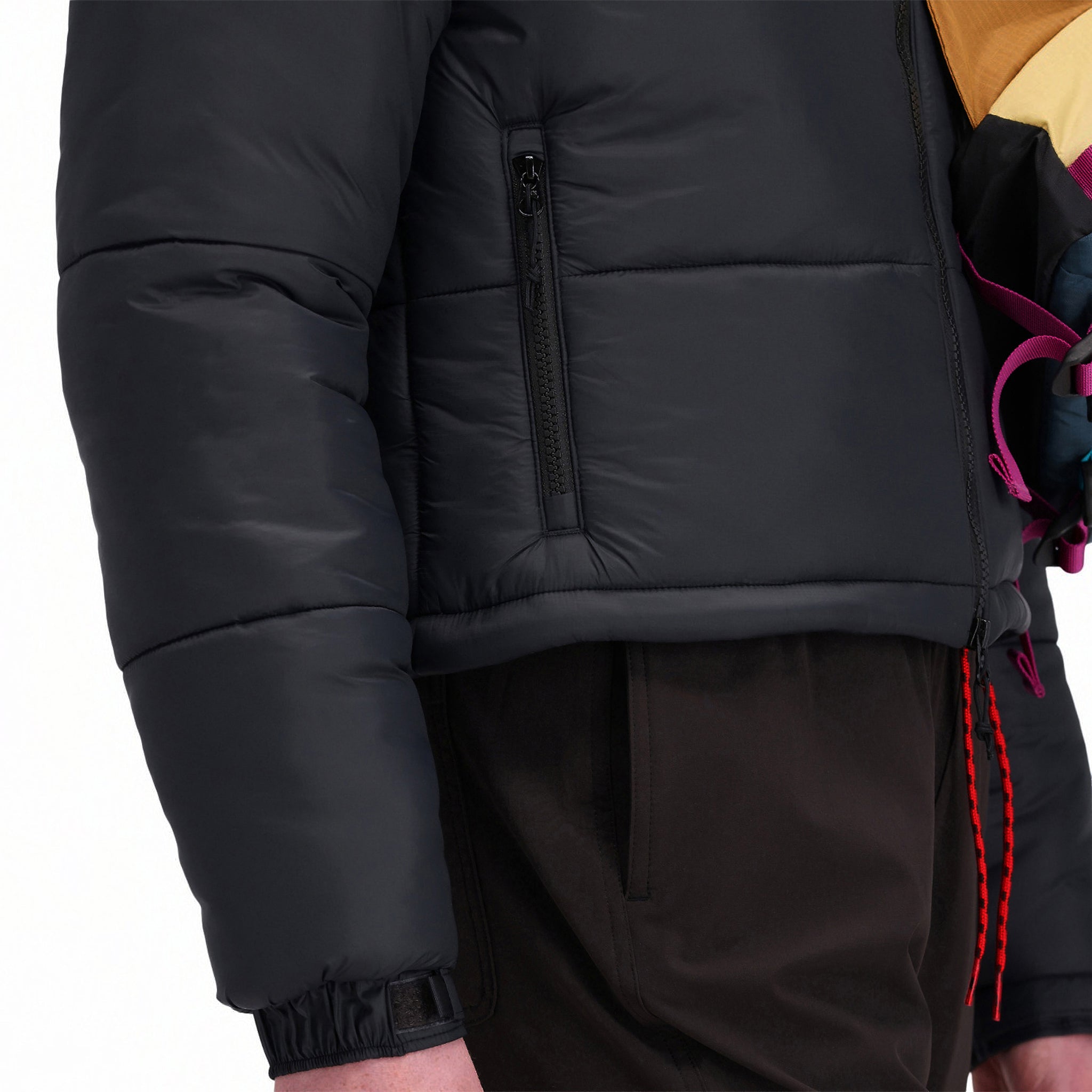 Front model shot of Topo Designs Women's Puffer recycled insulated Jacket in "Black" showing hand zipper pockets.