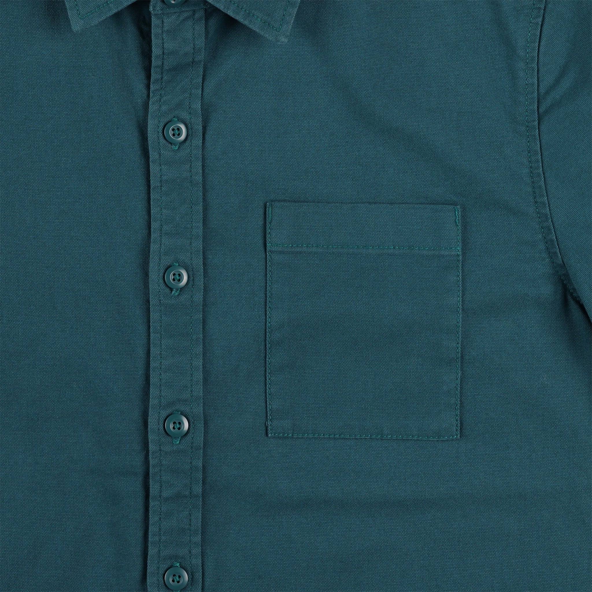 General shot of Topo Designs Men's Short Sleeve Dirt Shirt in pond blue showing close-up of buttons and check pocket.